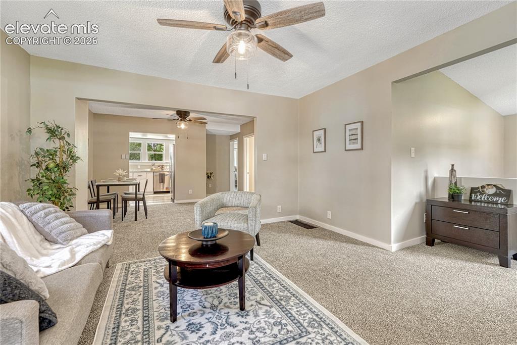 Image 5 of 41: Neutral tone wall paint, textured ceiling, and a ceiling fan with wood-fini