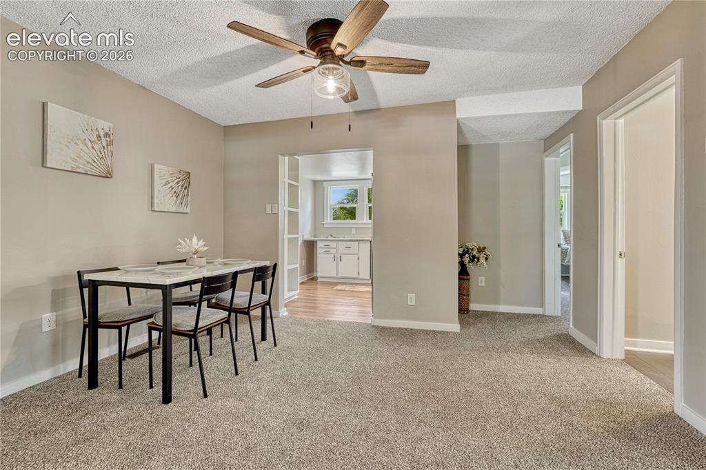 Image 6 of 41: Neutral tone wall paint with a textured ceiling, a ceiling fan with light f