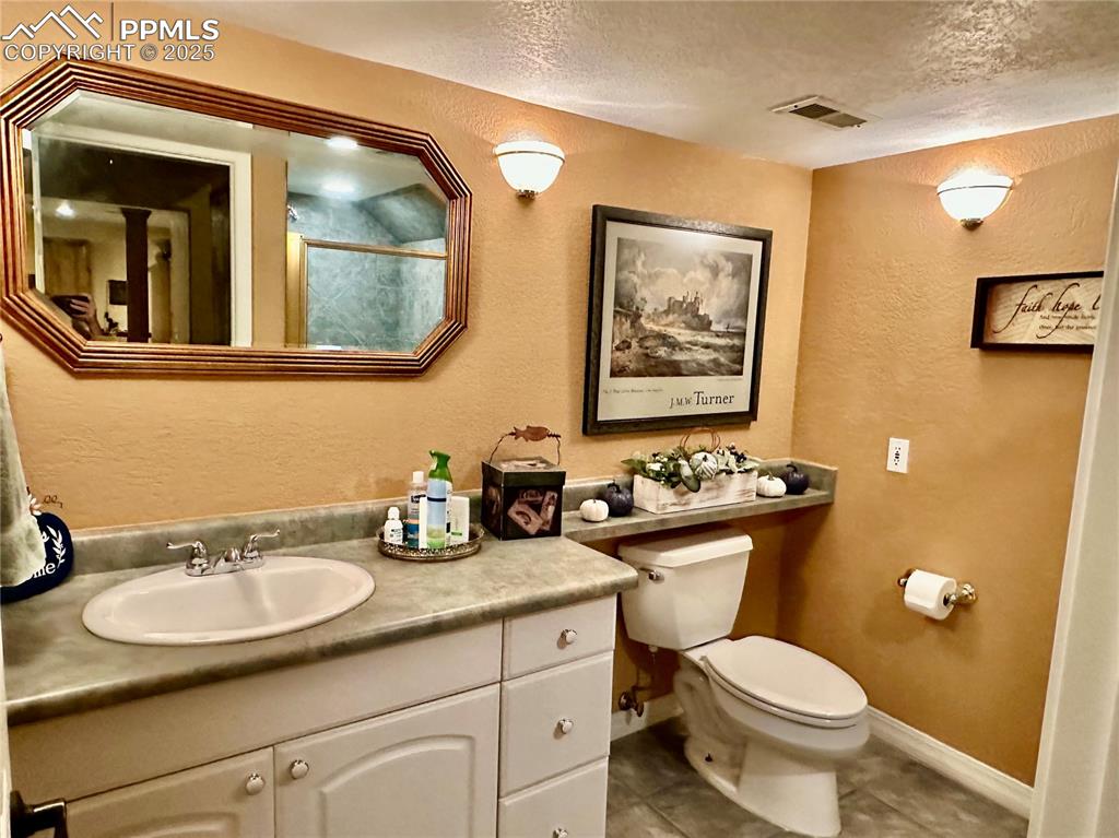 Image 14 of 41: Full bathroom with a textured wall, a stall shower, vanity, a textured ceil