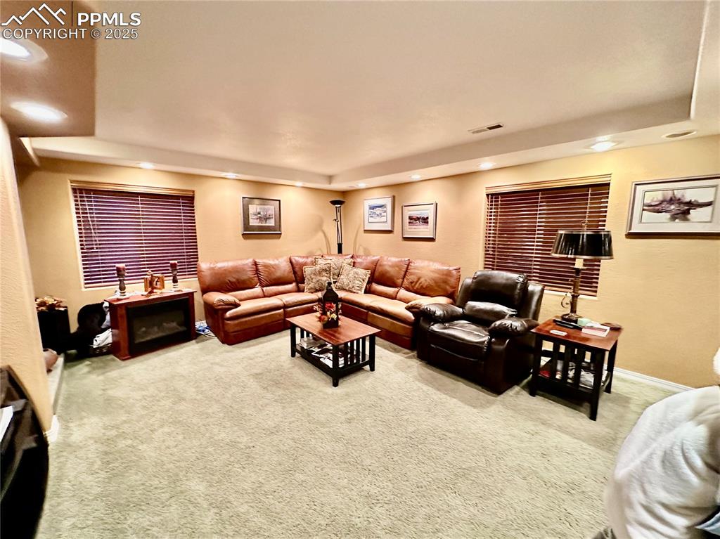 Image 22 of 41: Living room with light carpet and recessed lighting