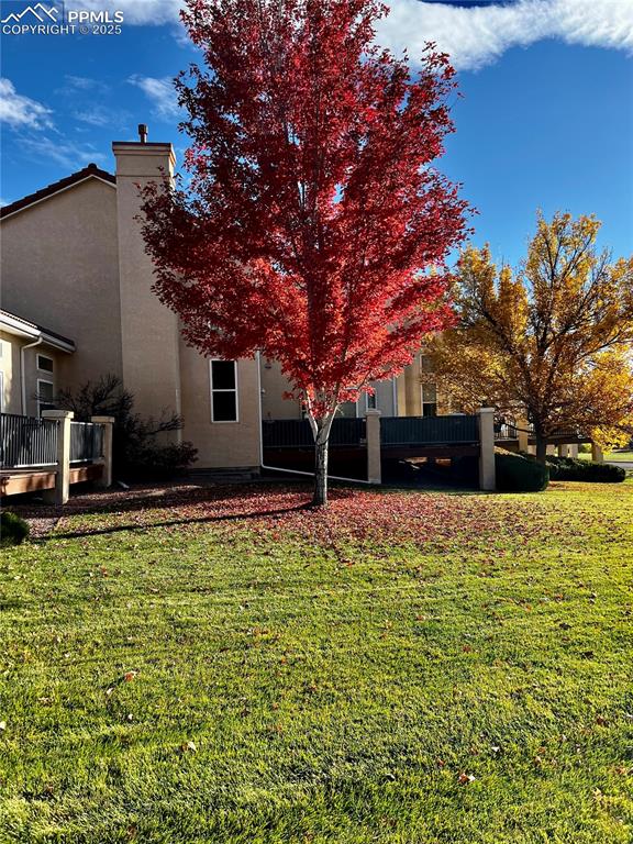 Image 35 of 41: Rear view of house featuring a yard, stucco siding, and a chimney
