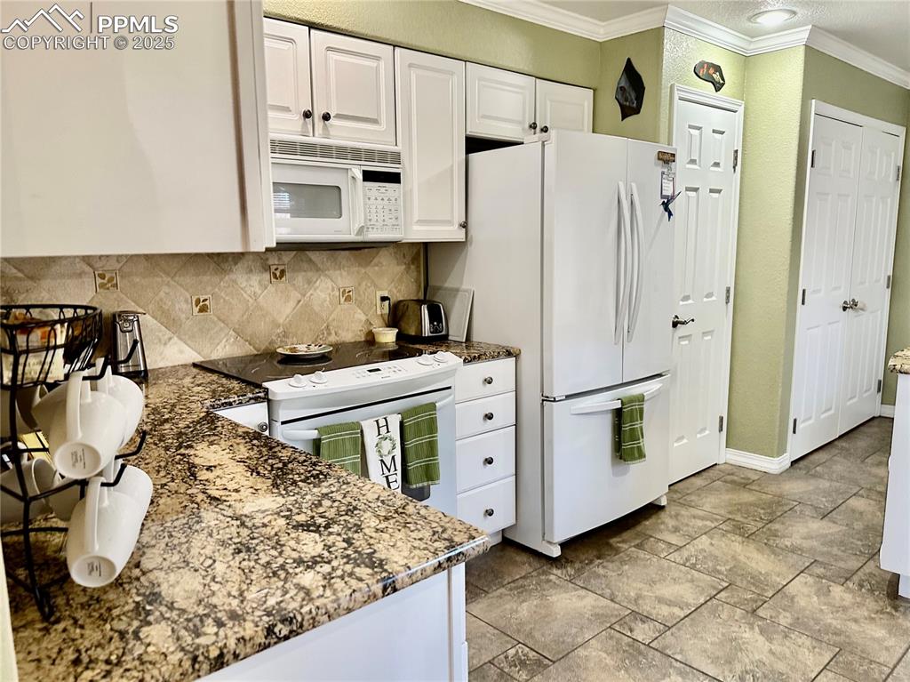 Image 4 of 41: Kitchen featuring white cabinetry, ornamental molding, white appliances, da