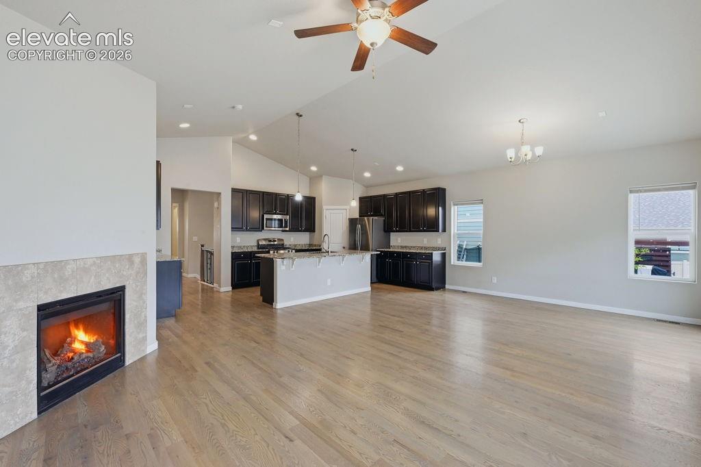 Image 18 of 40: Bright living area featuring wood-finish flooring, a tile-surround fireplac