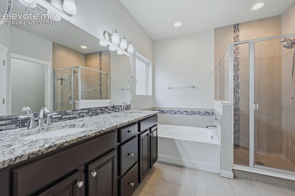 Image 24 of 40: Double vanity with granite countertop and dark wood cabinetry
