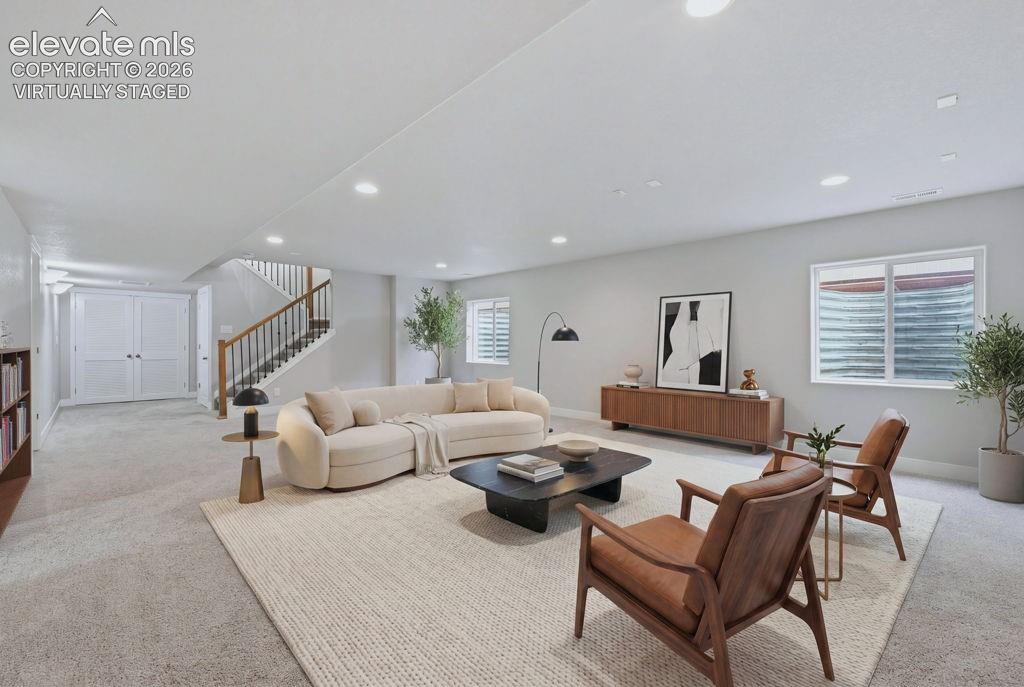 Image 27 of 40: Spacious living area featuring light-toned carpeting and recessed lighting
