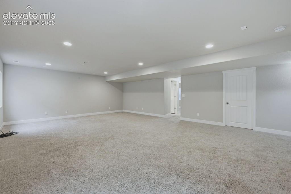 Image 30 of 40: Spacious room featuring light gray carpeting, recessed lighting, white base