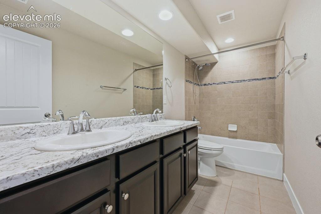 Image 32 of 40: Double vanity with granite-style countertop and undermount sinks, set upon