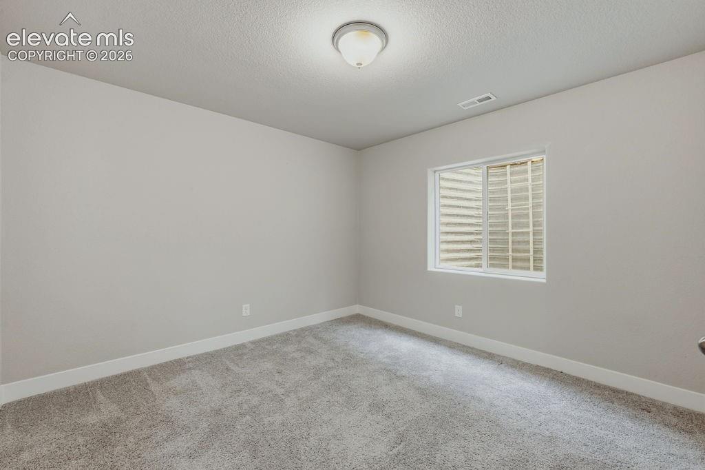 Image 34 of 40: Room featuring light gray wall paint, white trim, gray carpet flooring, and