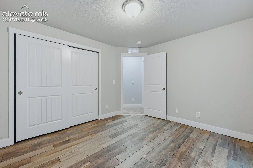 Image 36 of 40: Room featuring wood-finish flooring, light gray wall tones, and white trim
