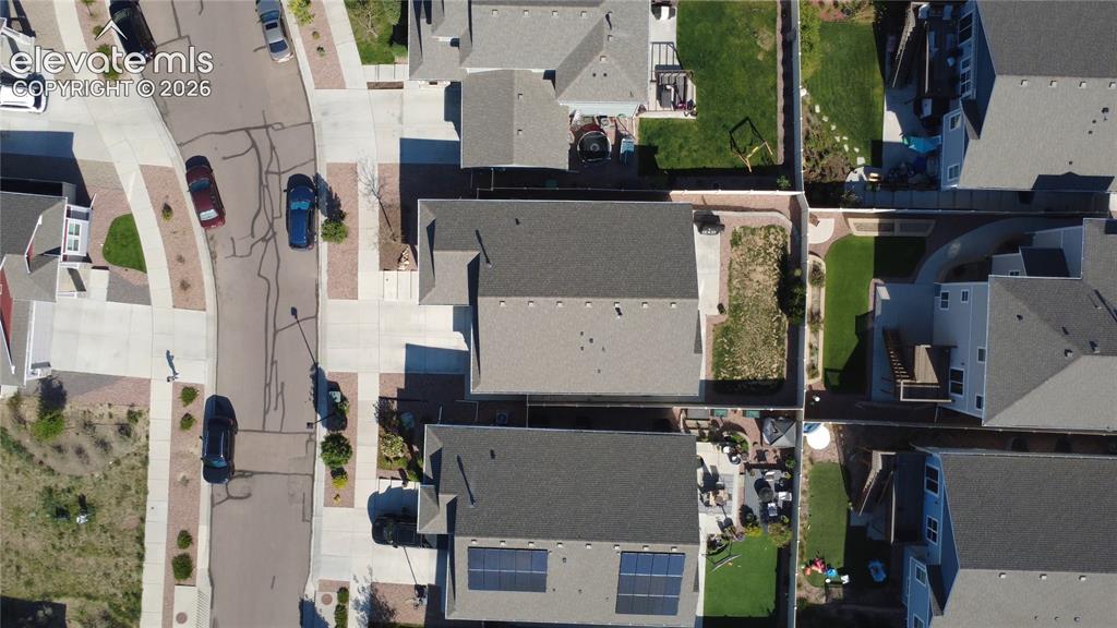 Image 39 of 40: Aerial perspective showcasing a residential street with homes featuring dar