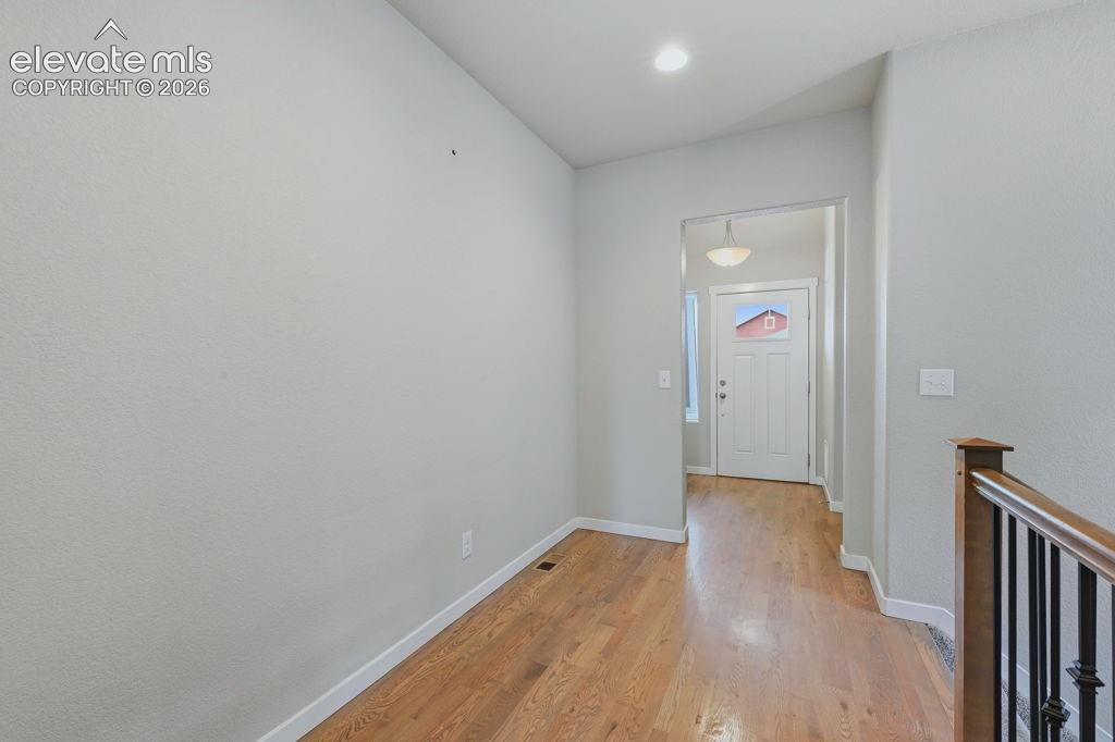 Image 4 of 40: Hallway featuring wood-finish flooring, light gray walls, white trim, and a
