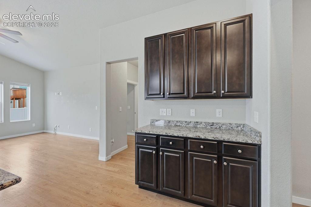 Image 9 of 40: Built-in cabinetry with dark wood-finish doors and a granite countertop