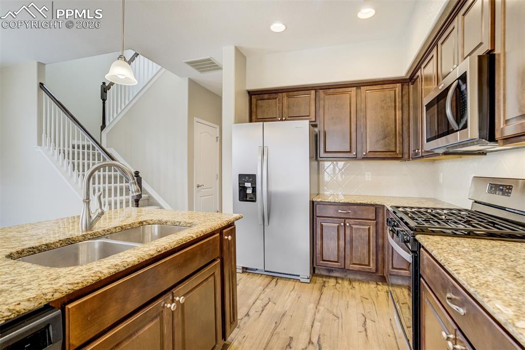 Image 10 of 35: Kitchen with brand new stainless steel appliances, an island with sink, pen