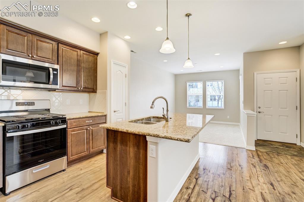 Image 11 of 35: Kitchen with brand new stainless steel appliances, an island with sink, pen