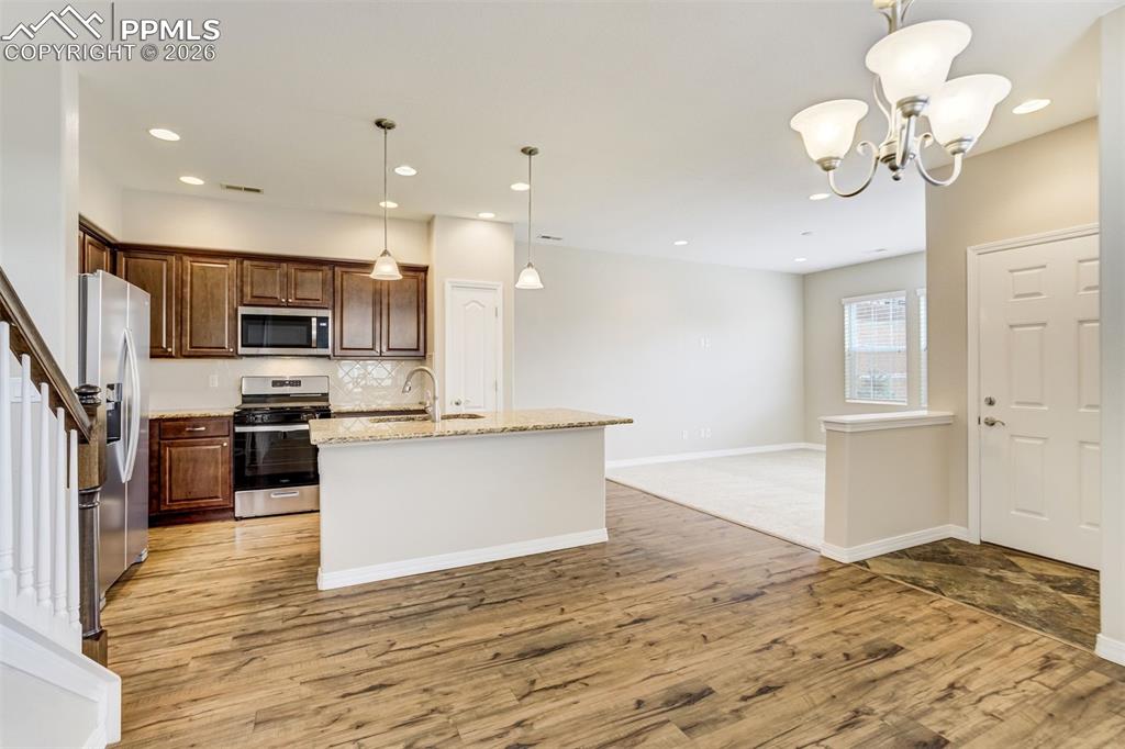 Image 14 of 35: Kitchen with brand new stainless steel appliances, an island with sink, pen