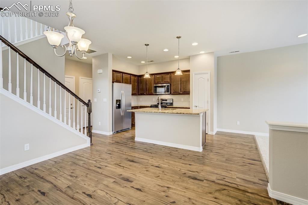 Image 15 of 35: Kitchen with brand new stainless steel appliances, an island with sink, pen