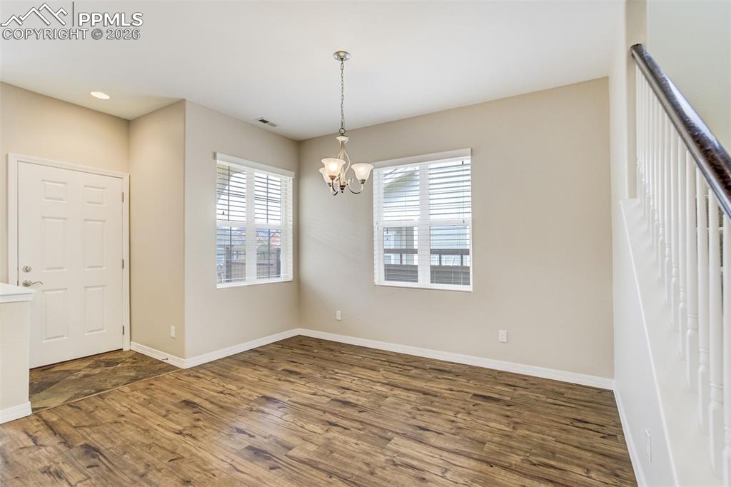 Image 16 of 35: Entrance foyer and dining room featuring dark wood-style floors and opening