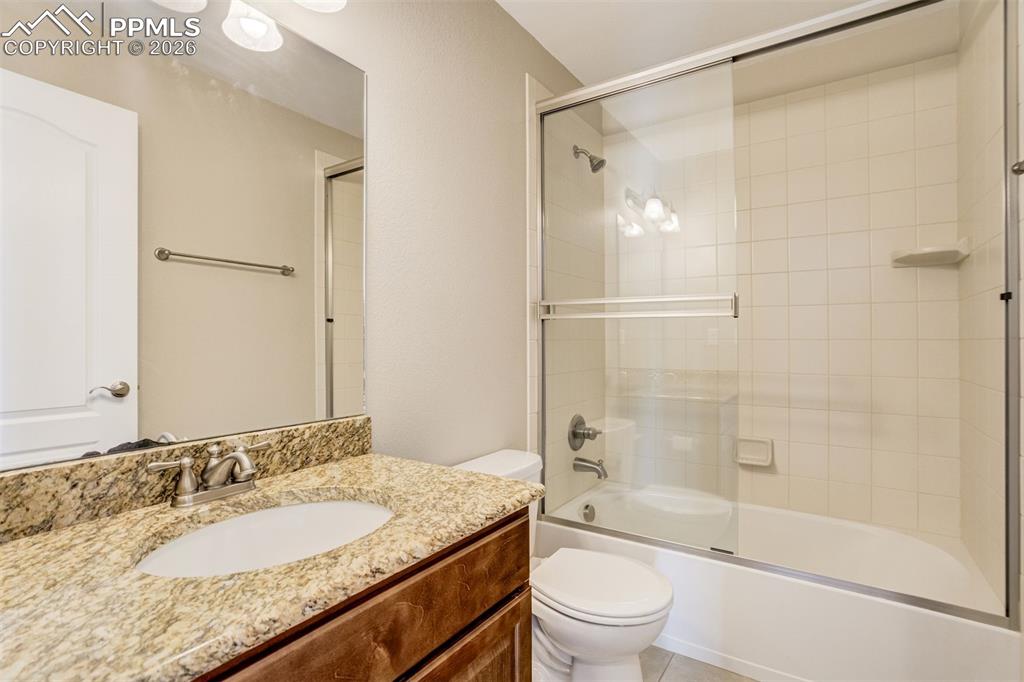 Image 31 of 35: Full bathroom in hall with vanity, bath / shower combo with glass door, and