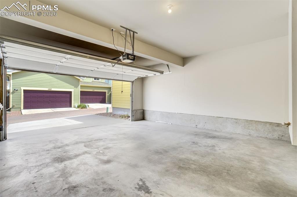 Image 33 of 35: View of oversized 2 car garage with full driveway.