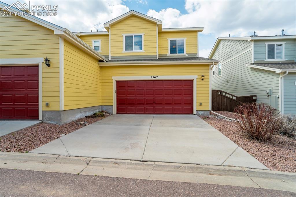 Image 35 of 35: Traditional-style townhome with driveway and an attached garage