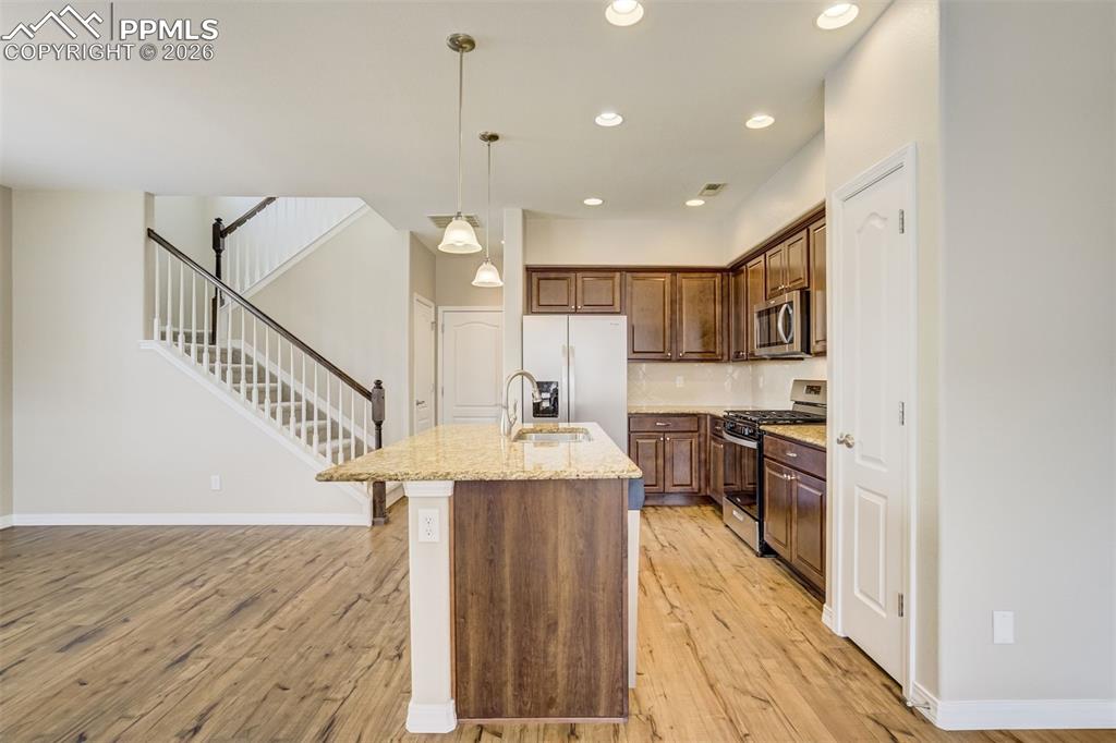 Image 9 of 35: Kitchen with brand new stainless steel appliances, an island with sink, pen