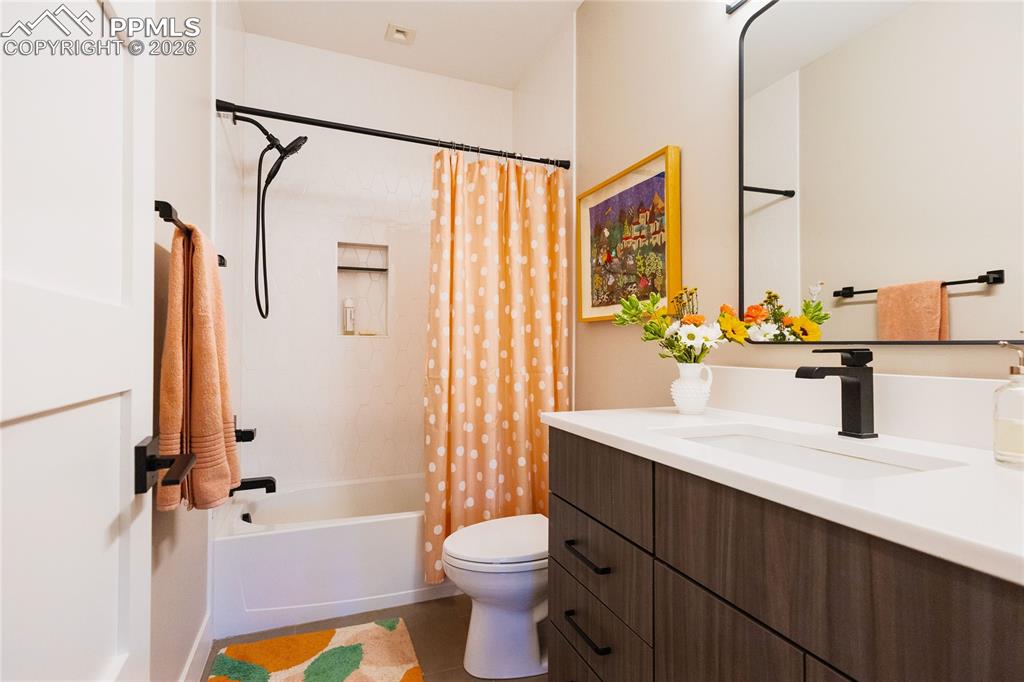 Image 33 of 49: Bathroom with vanity and shower / bath combo with shower curtain