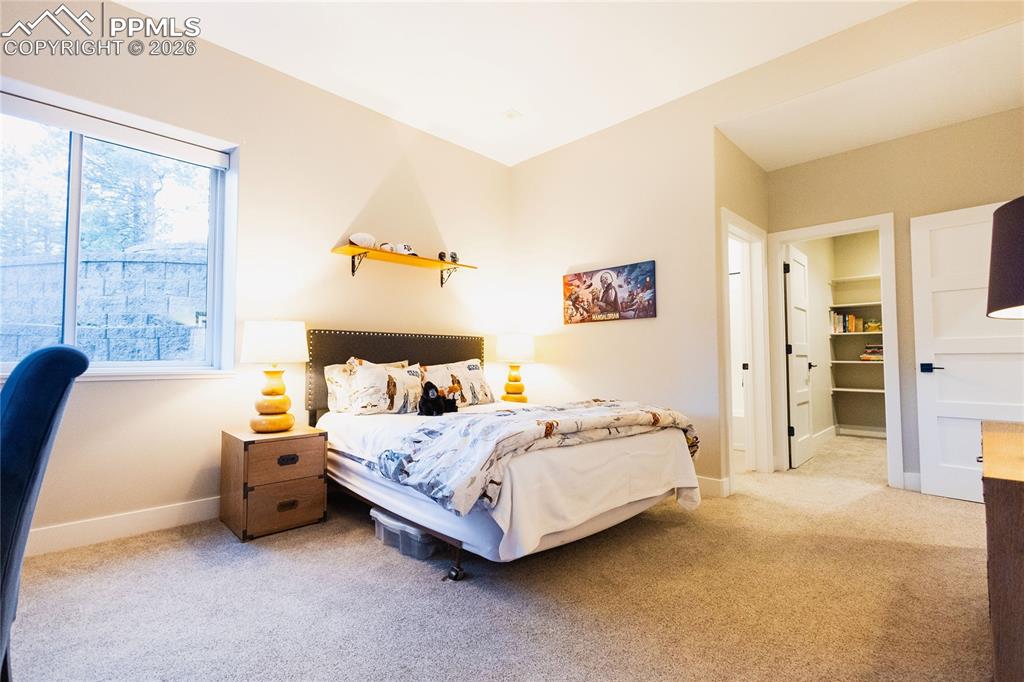 Image 34 of 49: Bedroom featuring light colored carpet and ensuite bathroom