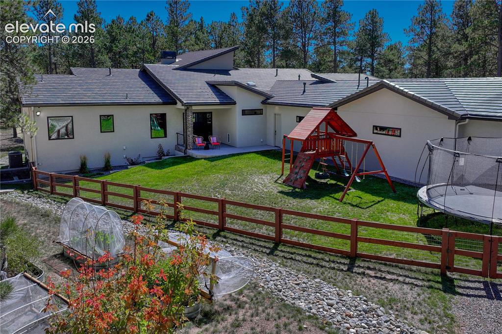 Image 38 of 49: Back of property featuring stucco siding, a patio area, a lawn, and a balco