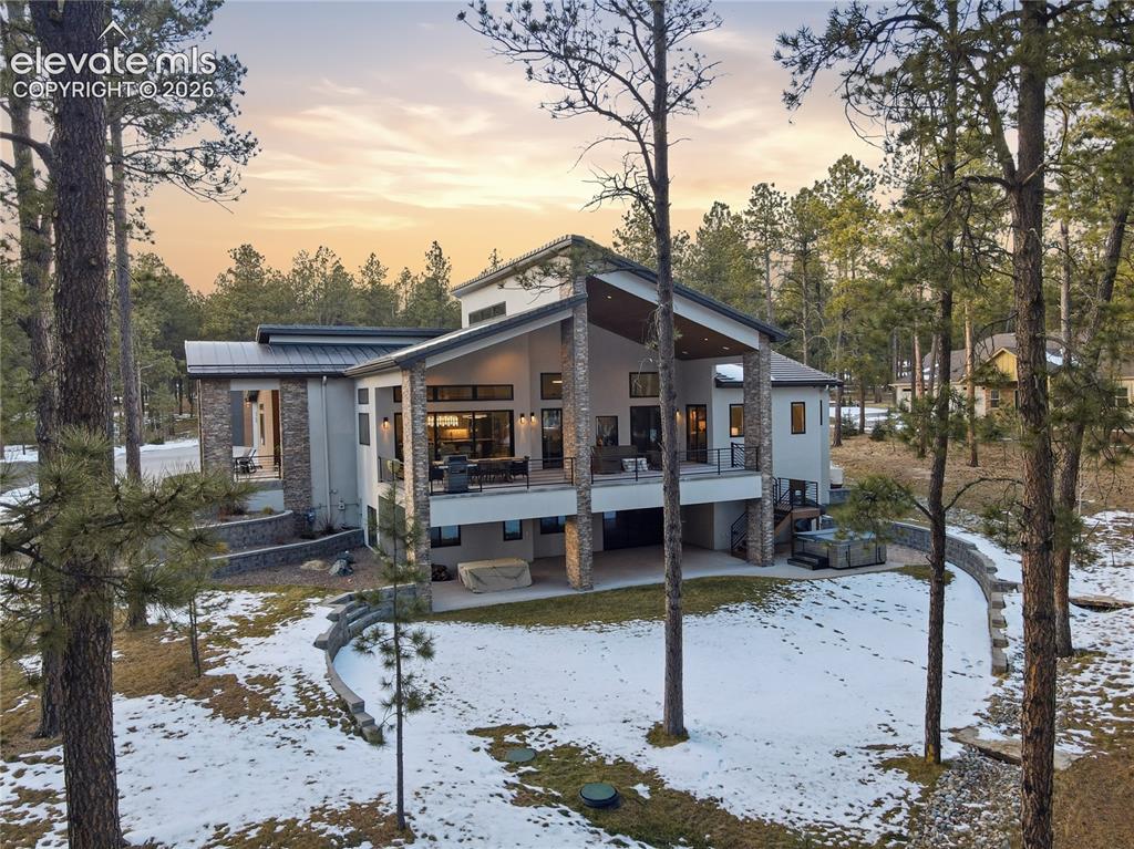 Image 40 of 49: Snow covered property with a patio area, stucco siding, a metal roof, view