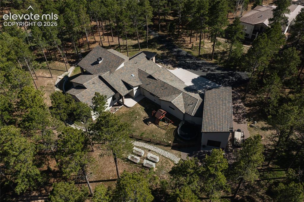 Image 44 of 49: View of subject property with a tree filled landscape