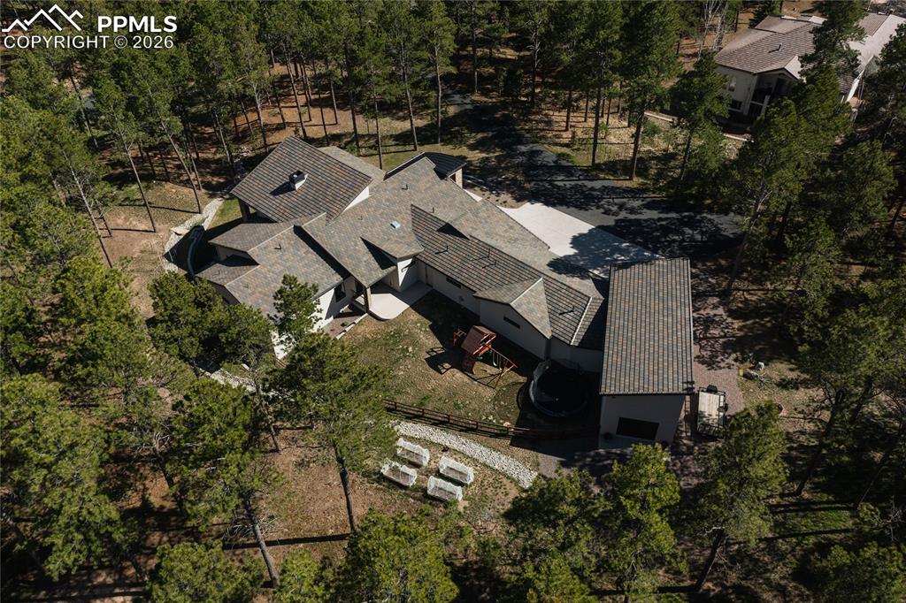 Image 45 of 49: View of subject property with a tree filled landscape