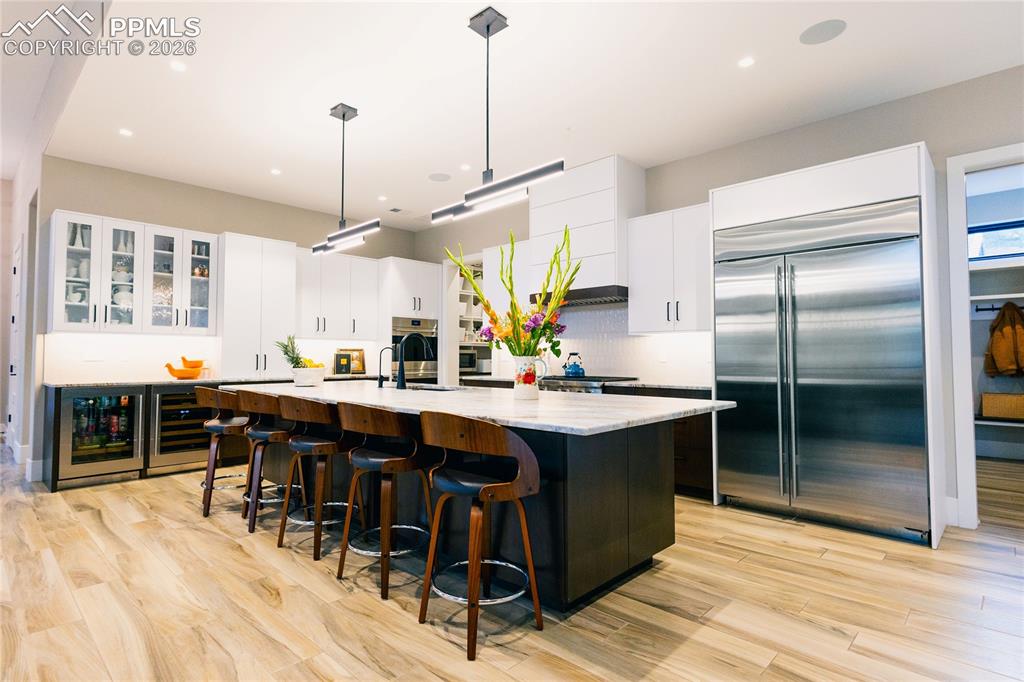 Image 9 of 49: Two tone kitchen with two tone cabinetry, stainless steel appliances, a lar
