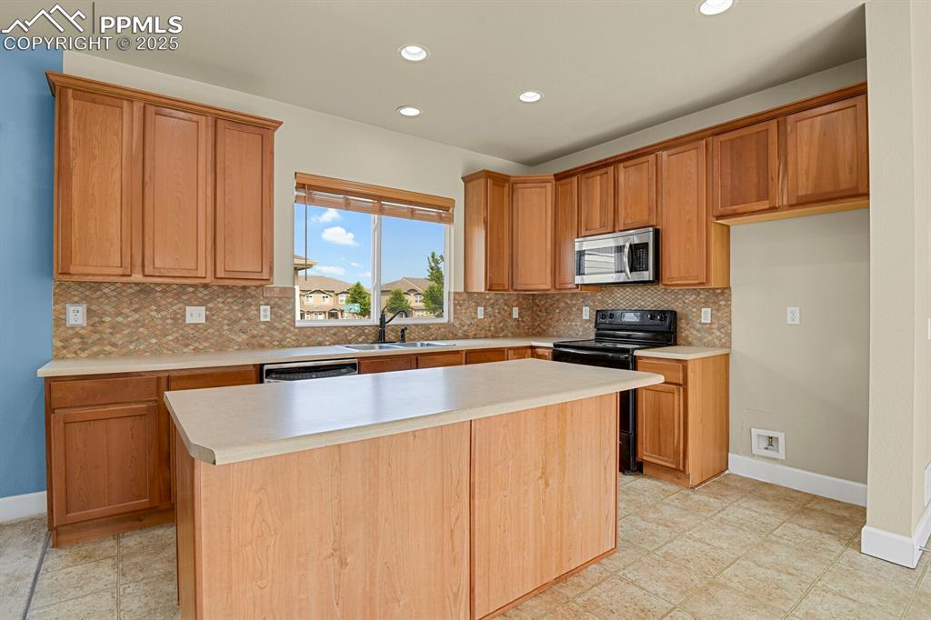Image 16 of 35: Kitchen featuring appliances with stainless steel finishes, tasteful backsp