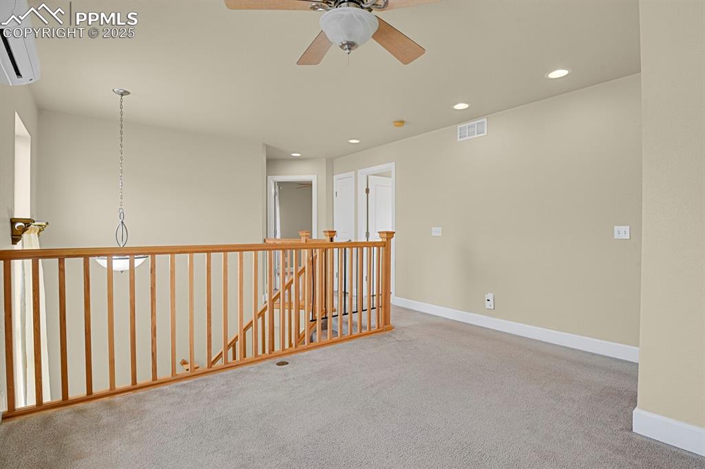 Image 24 of 35: Unfurnished room with carpet flooring, a ceiling fan, a wall unit AC, and r