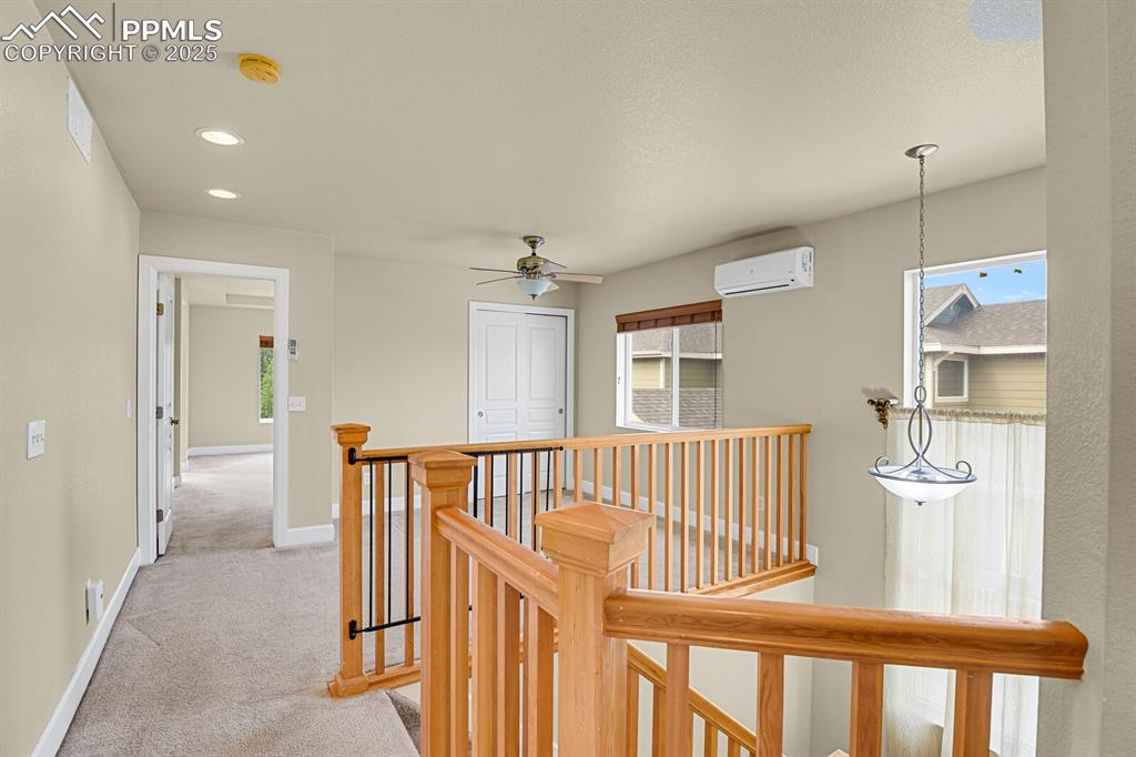 Image 26 of 35: Hallway featuring an upstairs landing, light carpet, recessed lighting, and