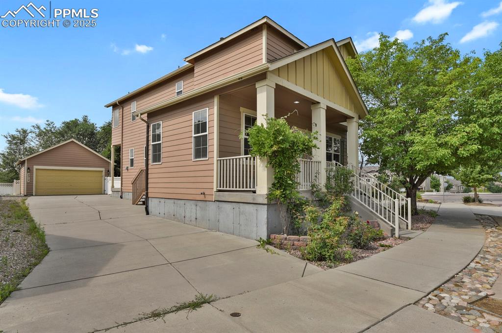 Image 3 of 35: View of front of house with covered porch, a detached garage, an outdoor st