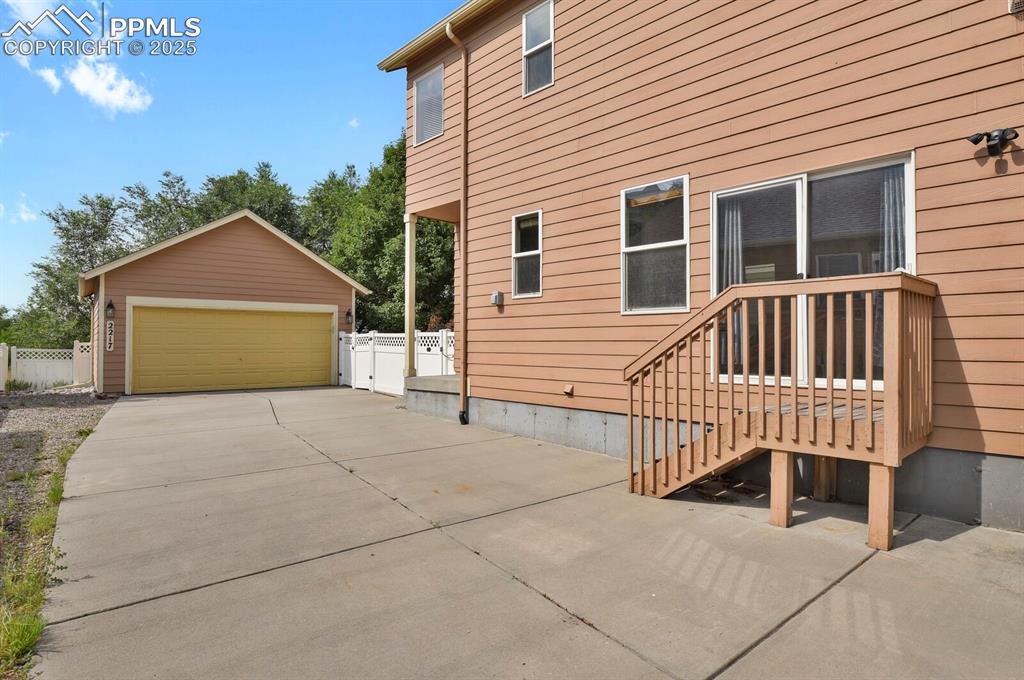 Image 31 of 35: View of side of home featuring a detached garage and an outdoor structure