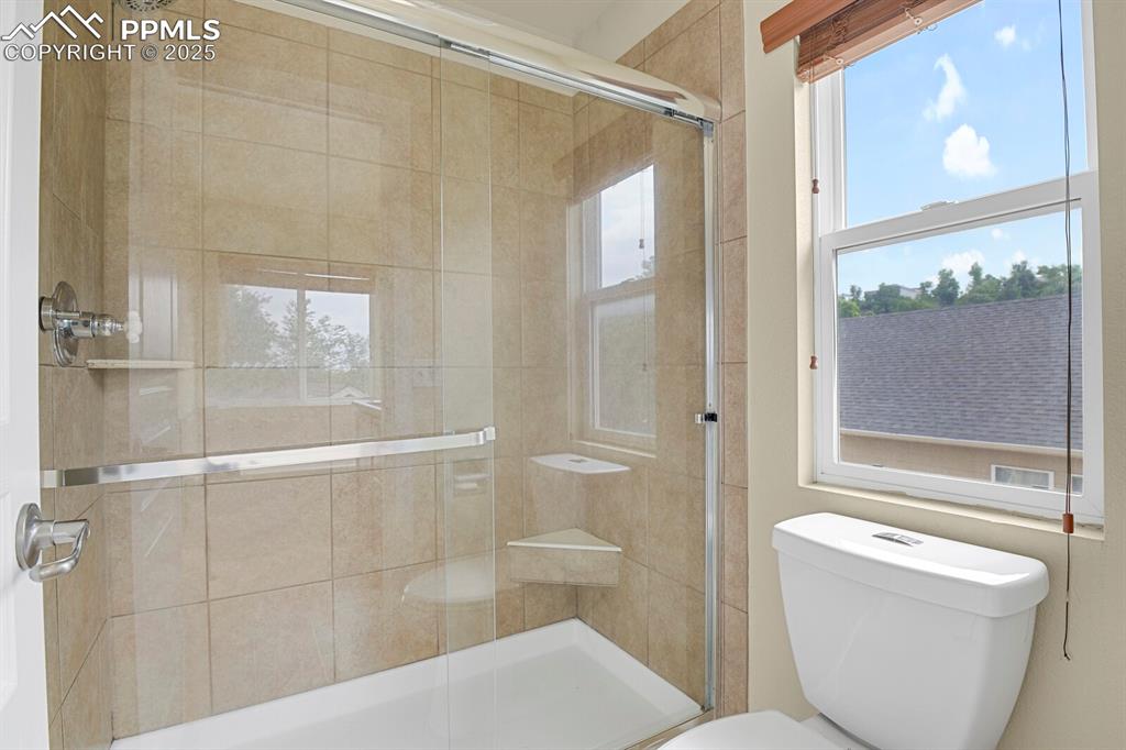 Image 33 of 35: Full bathroom with toilet and a stall shower