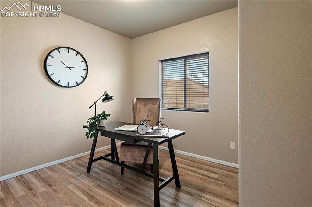 Image 22 of 41: Bedroom 2 on main floor featured as an office. New LVP