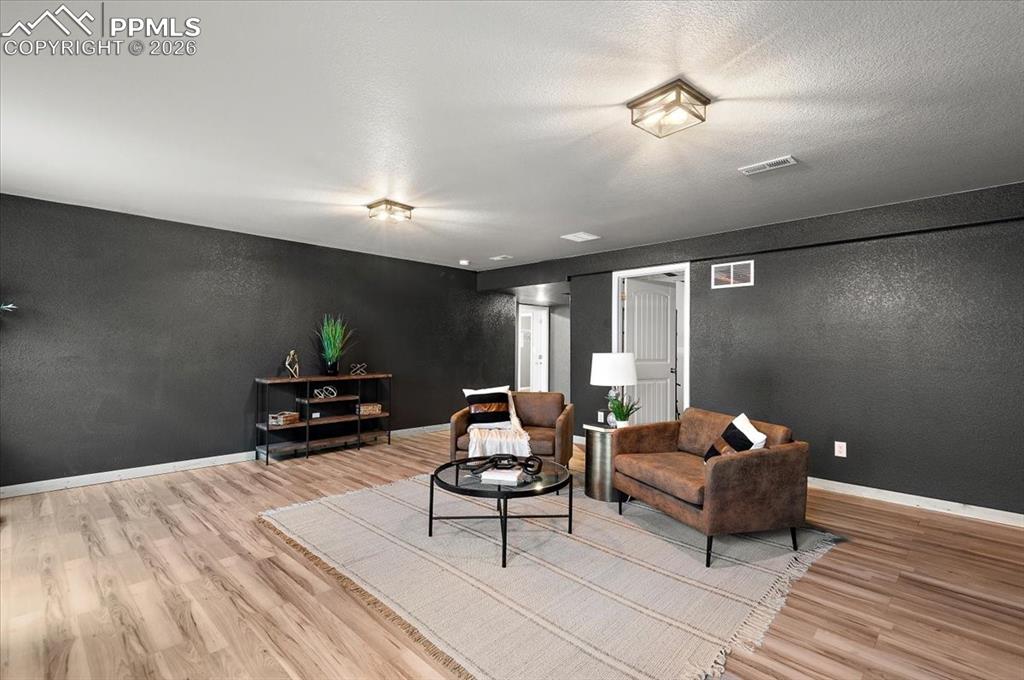 Image 25 of 41: Large basement living room, new LVP, new light fixtures, new paint and hard
