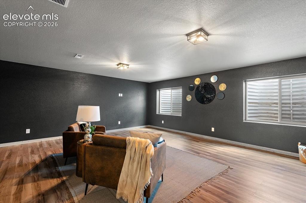 Image 25 of 40: Large basement living room, new LVP, new light fixtures, new paint and trim