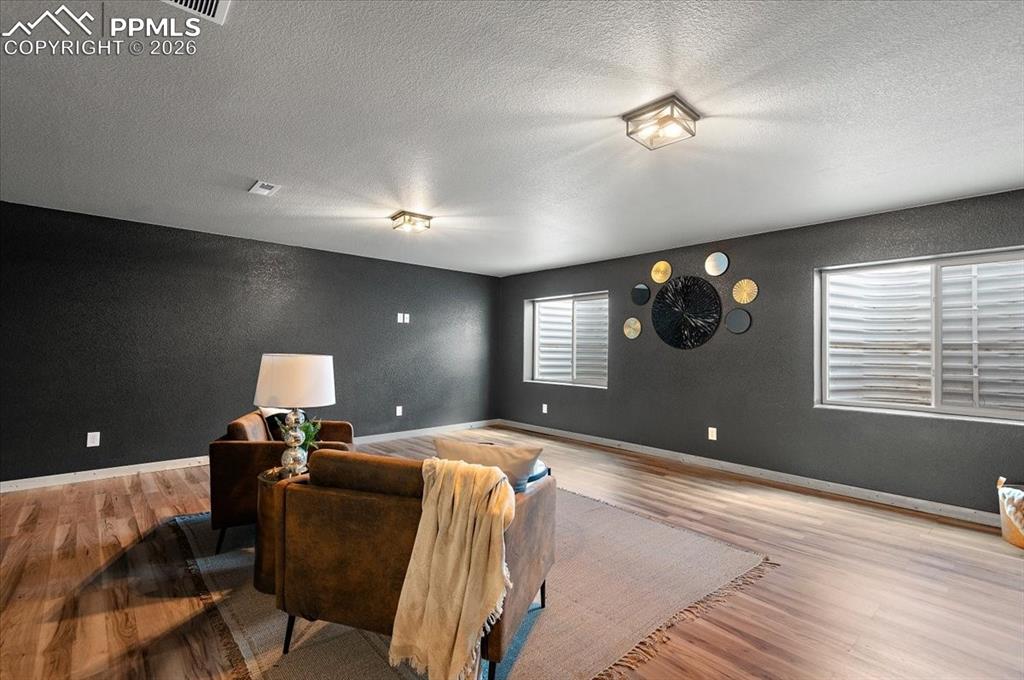 Image 26 of 41: Large basement living room, new LVP, new light fixtures, new paint and trim