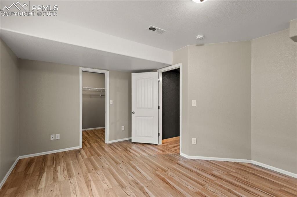 Image 27 of 41: Bedroom 4 in basement with LVP and walk-in closet