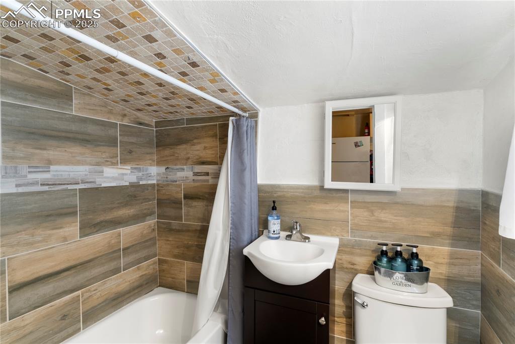 Image 9 of 15: Full bath featuring shower / bathtub combination with curtain, vanity, loft