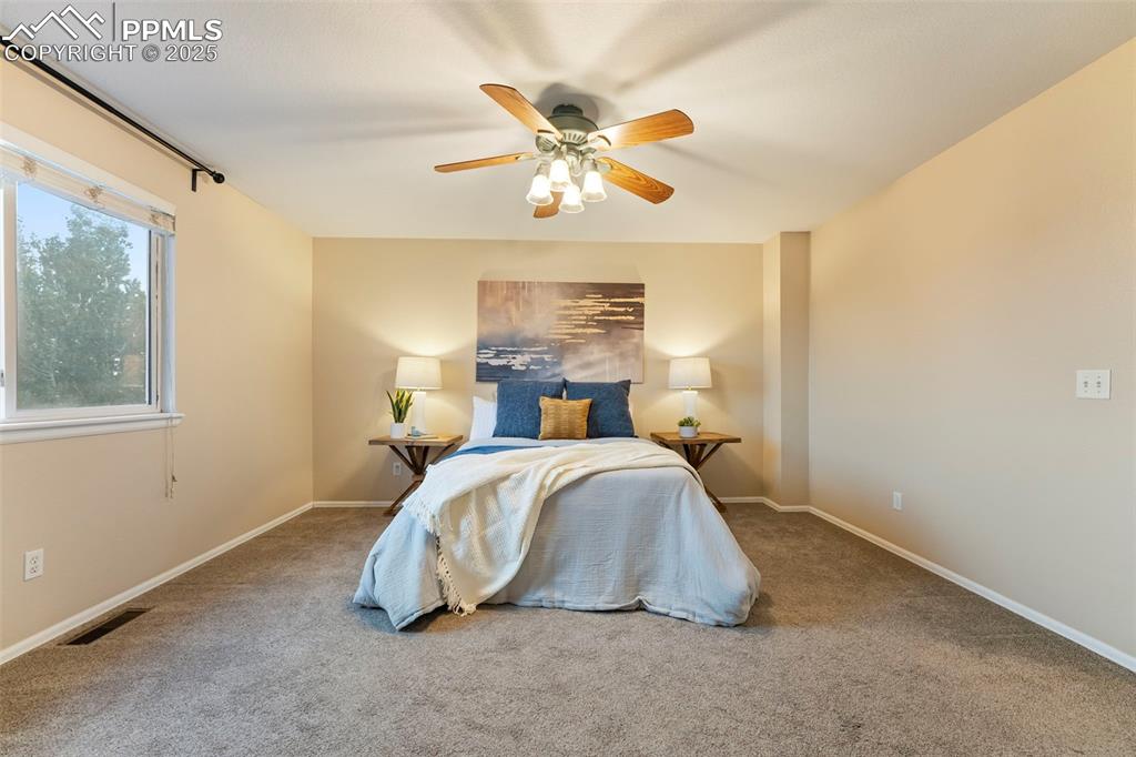 Image 12 of 31: Carpeted bedroom with baseboards and ceiling fan