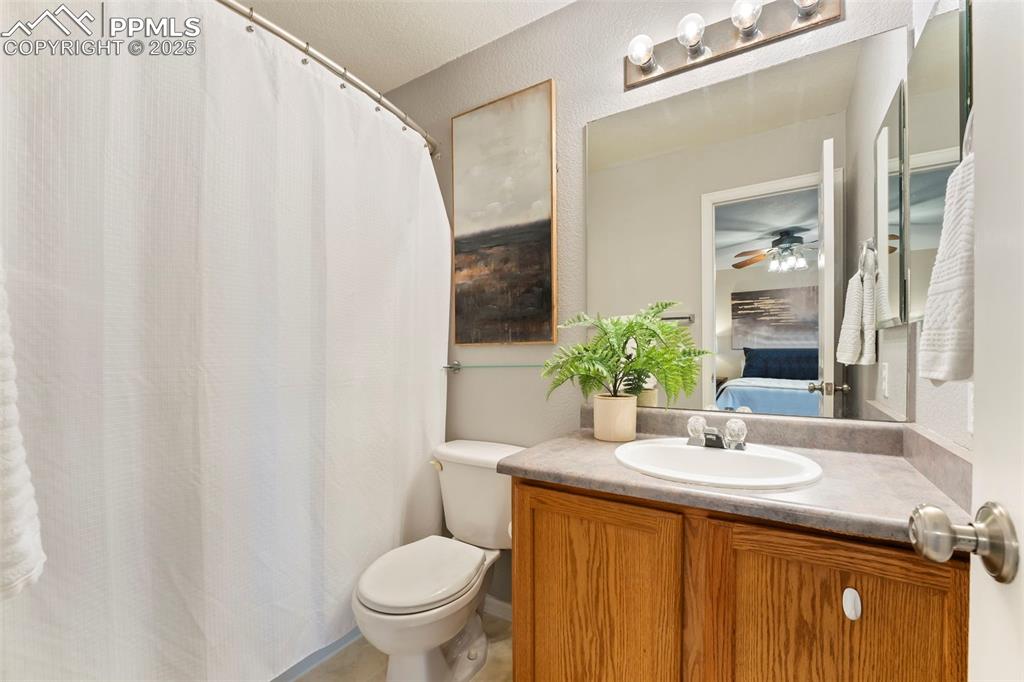 Image 14 of 31: Full bath with vanity, a ceiling fan, and curtained shower