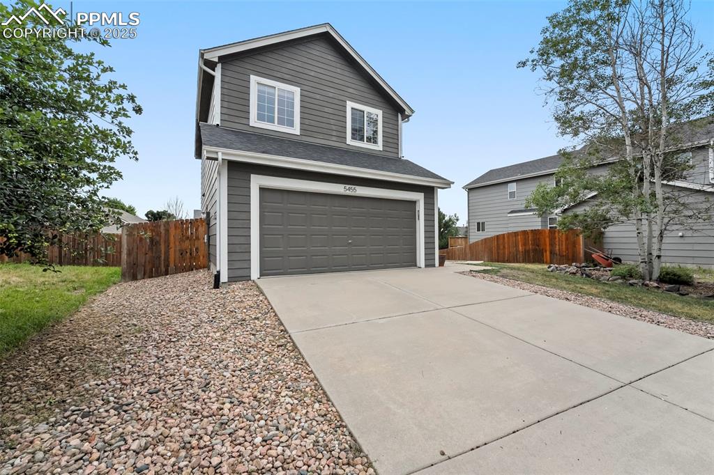 Image 2 of 31: Traditional home with driveway, a garage, and a shingled roof