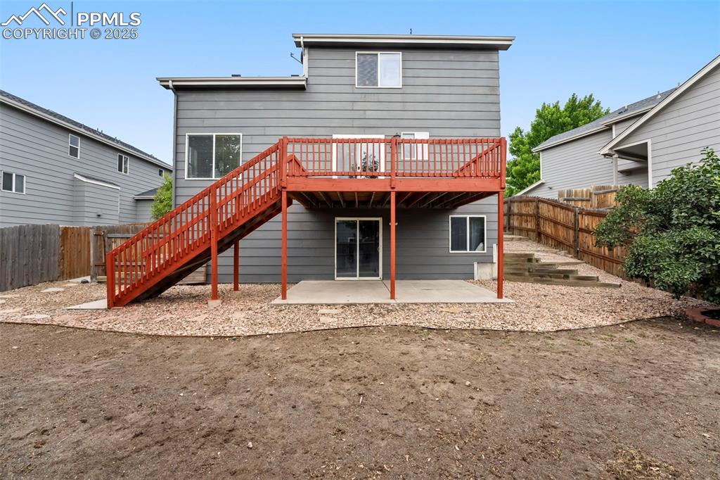Image 24 of 31: Back of property with a wooden deck, a patio, a fenced backyard, and stairw