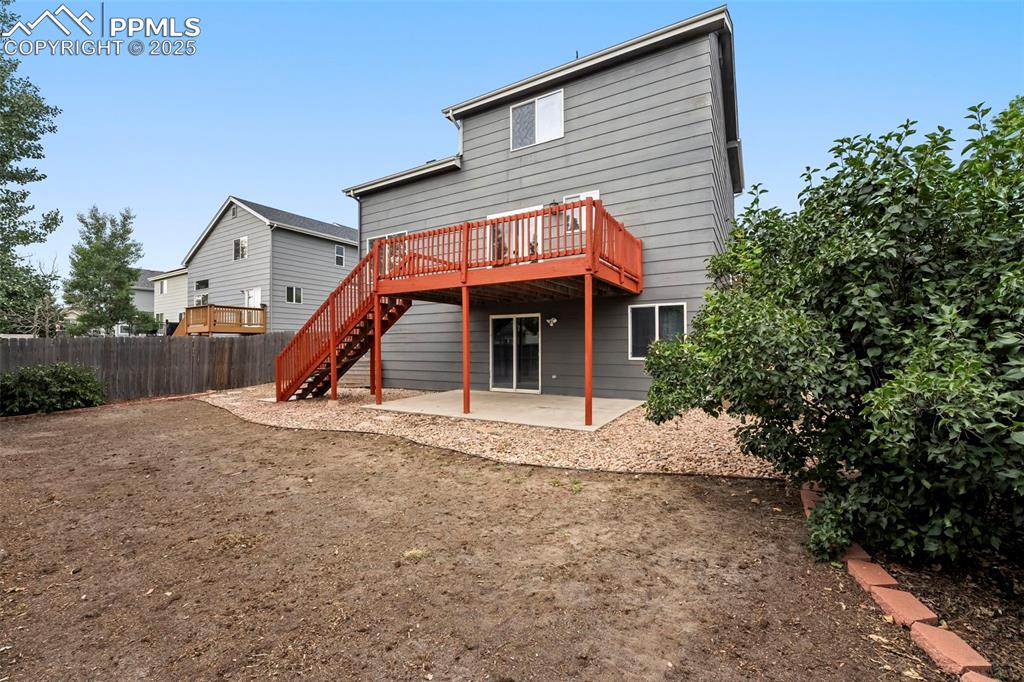 Image 25 of 31: Back of property with stairway, a patio, and a wooden deck