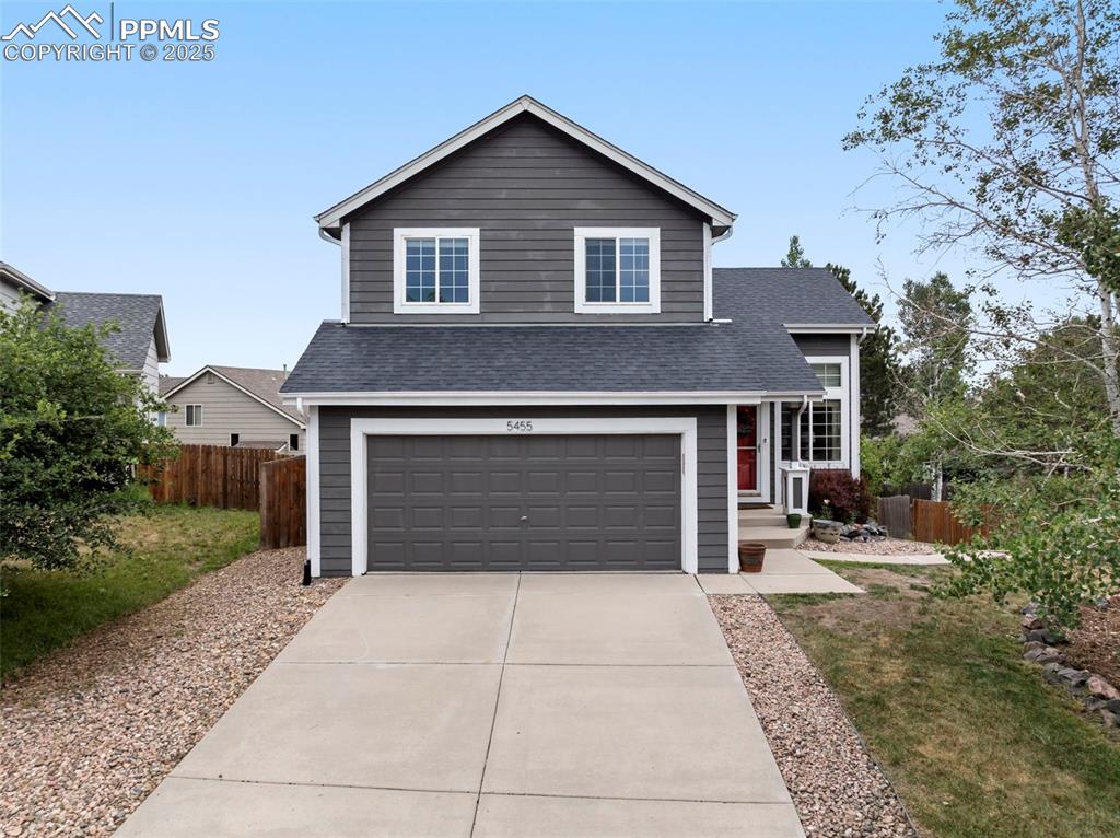 Image 27 of 31: Traditional-style house with an attached garage, concrete driveway, and a s